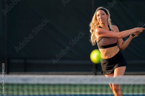 A Lovely Blonde Model Plays Tennis Outdoors In The Summer Sun