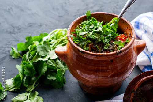 a pot with vats of greens and a towel on a dark background