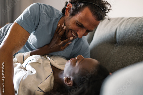 Loving boyfriend lying on black girlfriend