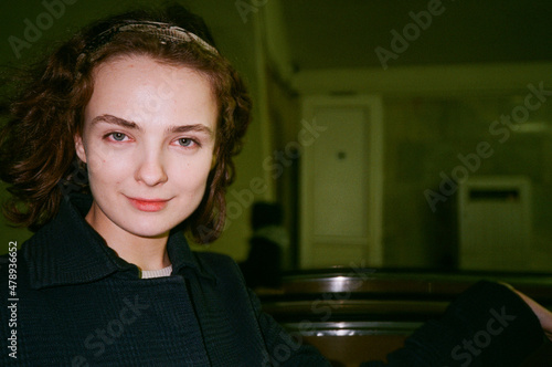 Curly hair model with sarcastic face in the metro