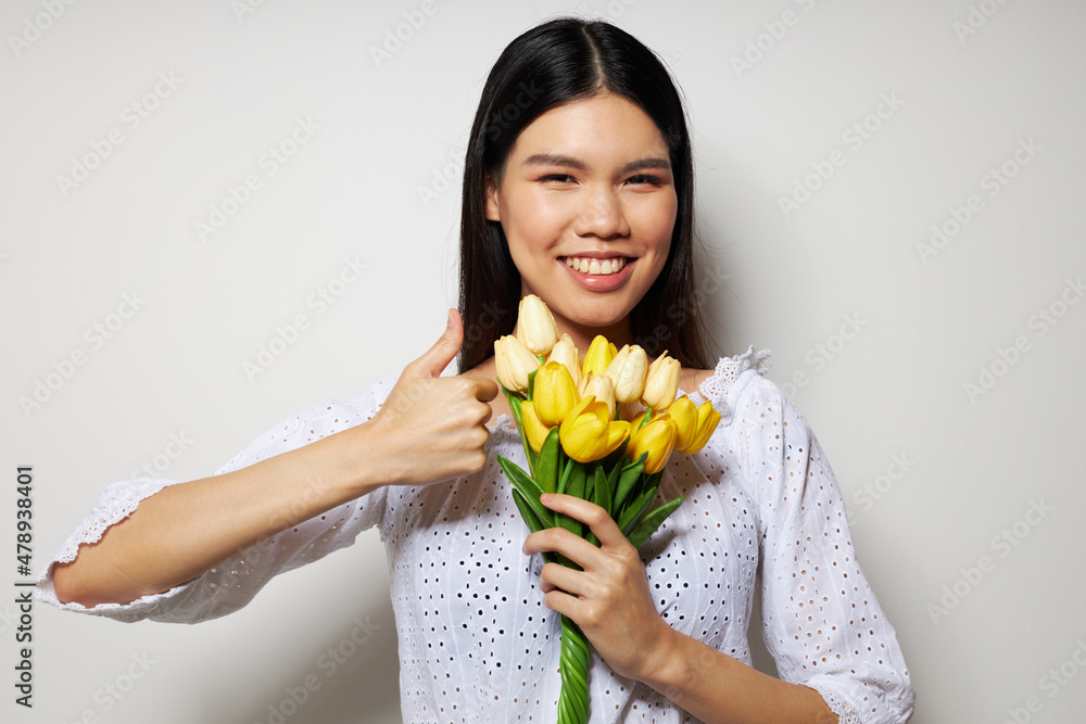 woman with Asian appearance romance bouquet of flowers near the face studio model unaltered woman with Asian appearance romance bouquet of flowers near the face studio model unaltered