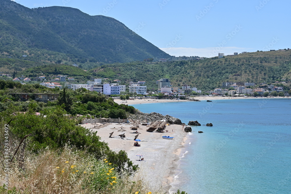 Saranda in Albania with panoramic view of the sandy beach and coastline with blue sea, mountains in the background and blue sky in summer