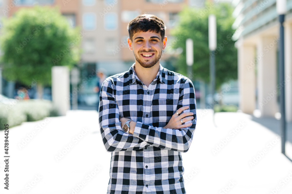handsome, smiling guy posing for the camera with his arms folded handsome, smiling guy posing for the camera with his arms folded