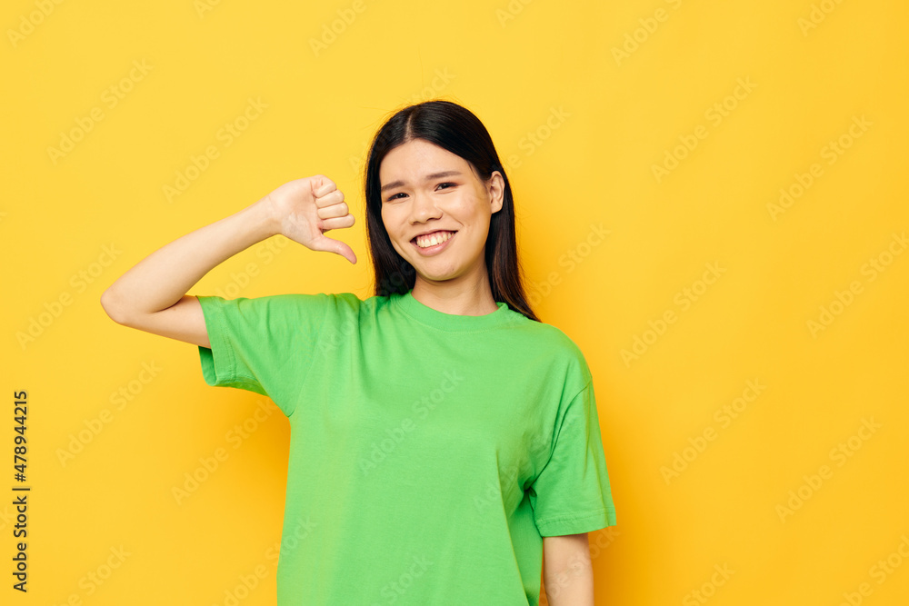 woman with Asian appearance posing in green t-shirt emotions copy-space isolated background unaltered woman with Asian appearance posing in green t-shirt emotions copy-space isolated background unaltered