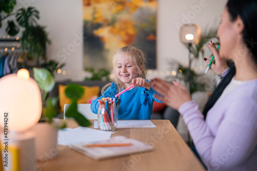 Girl and nanny talking while drawing