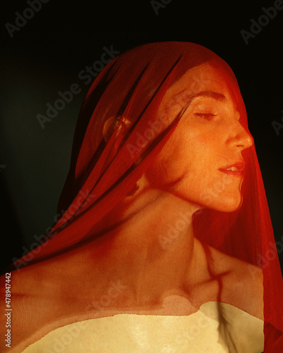 A portrait of a girl covered with a red material photo