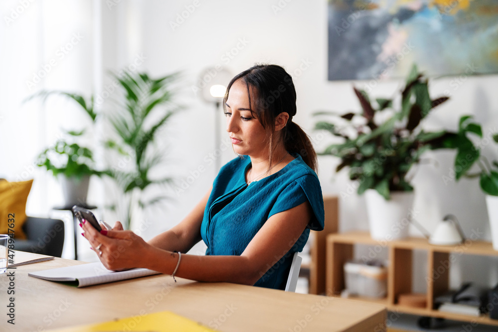 Woman using smartphone in office Woman using smartphone in office