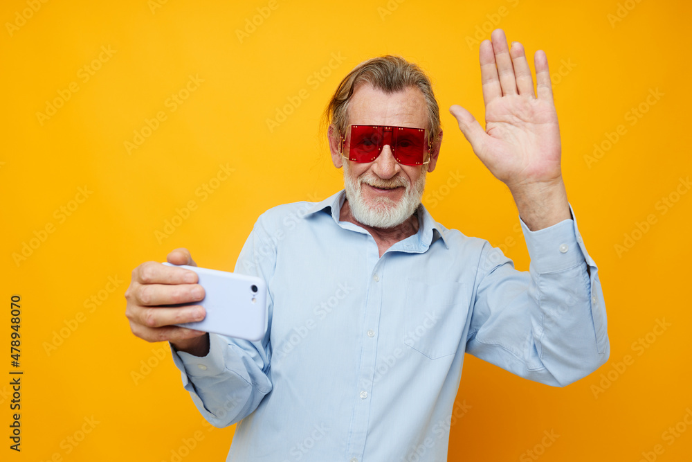 Naklejka premium Senior grey-haired man blue shirts with glasses takes a selfie cropped view