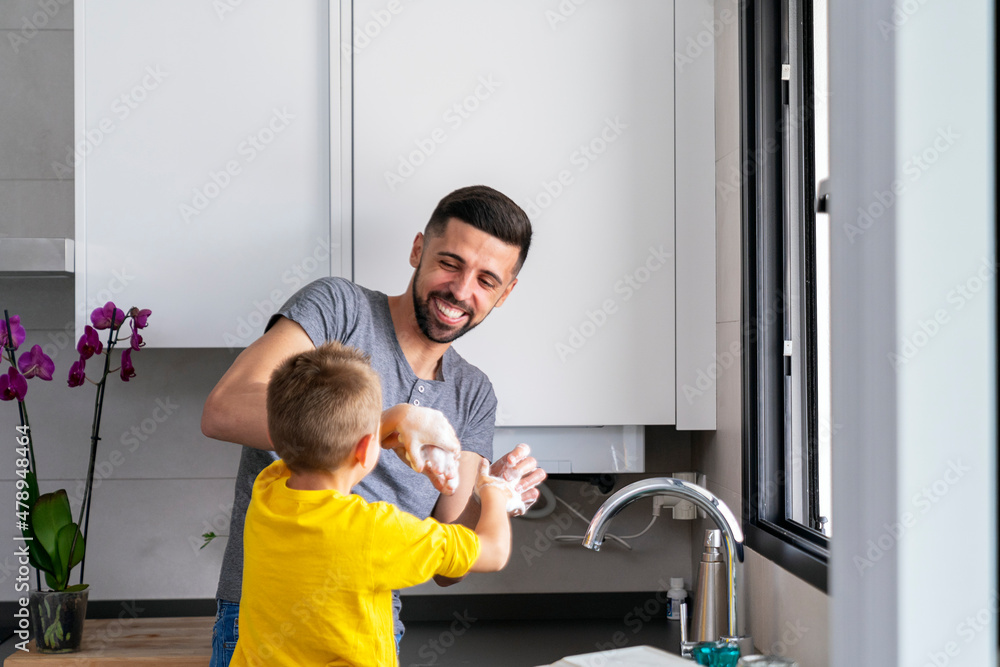 man having fun playing with his son in the kitchen man having fun playing with his son in the kitchen