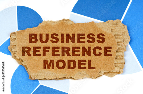 On the blue financial charts is a piece of cardboard that says - Business Reference Model photo