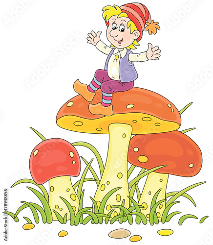 Merry little gnome sitting on a big mushroom and waving his hands in greeting among green grass on a summer forest glade, vector cartoon illustration isolated on a white background