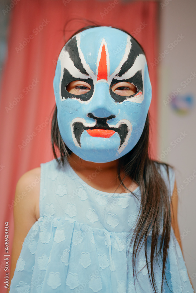 Asian child with a painting opera mask Asian child with a painting opera mask