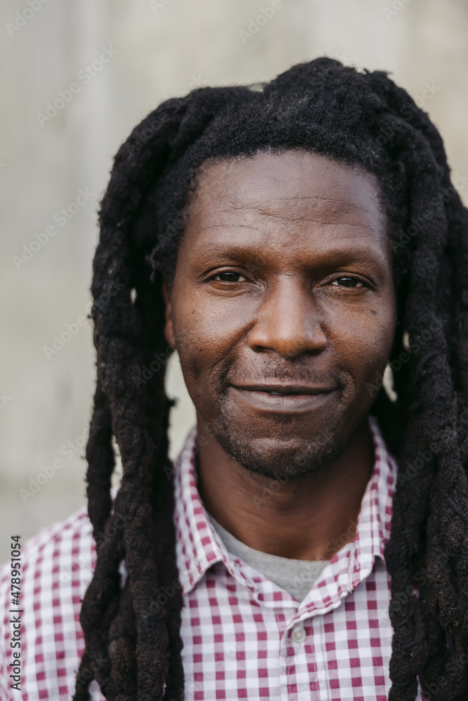 Smiling man with dreadlocks and plaid shirt. Smiling man with dreadlocks and plaid shirt.