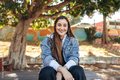 Bilde på lerret Cheerful teenage girl smiling at the camera in an urban park