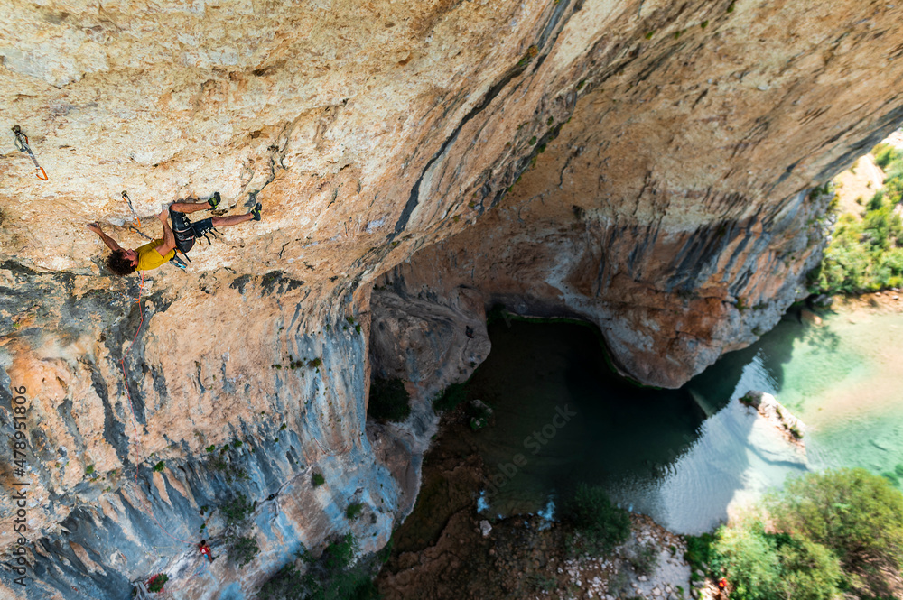 Climber rock climbing in cave Climber rock climbing in cave