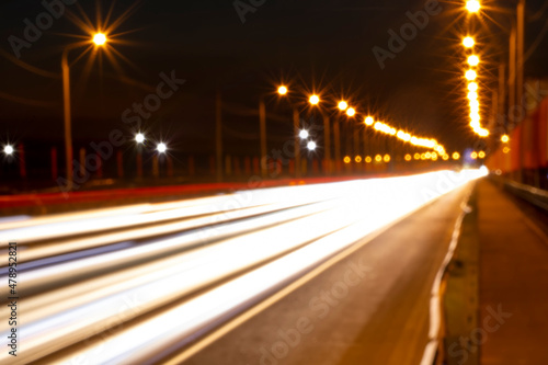 Moving car with blur light through roads and highways in twilight city. Night cityscape.