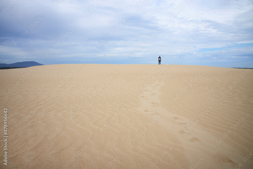 Person walking a sand dune Person walking a sand dune