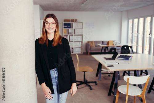 Relaxed young businesswoman in a large open plan office