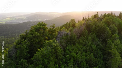Aerial Forward Shot Of Man Standing On Hilltop Amidst Forest - Thuringia, Germany