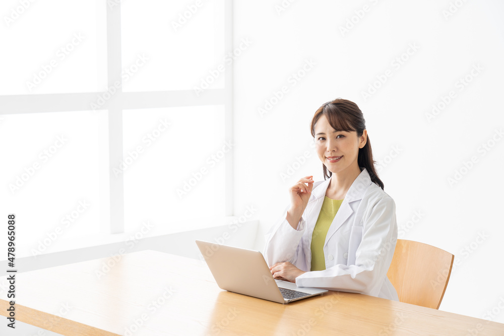 パソコンを使う若い女性の医者