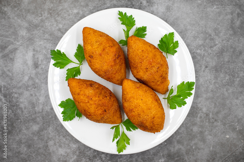 Kibbeh on a dark background. Kibbeh is a popular dish in Middle Eastern cuisine. Stuffed Meatballs Food, Falafel, icli Kofta, Quibe. Top view. Close up Kibbeh on a dark background. Kibbeh is a popular dish in Middle Eastern cuisine. Stuffed Meatballs Food, Falafel, icli Kofta, Quibe. Top view. Close up