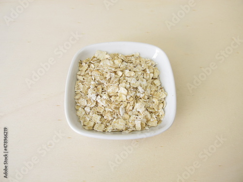 Fine rolled oats flakes on a wooden board