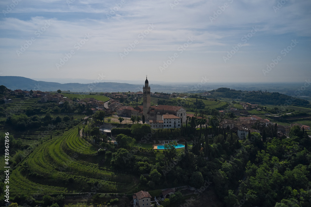 Catholic church on a hill surrounded by vineyards. Parish Church of Saints Fermo and Rustico, on a hill in the province of Verona, Colognola Ai Colli, Italy. Italian historic town on a hill.