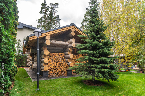 The courtyard of a country house with an original wooden structure for storing firewood.