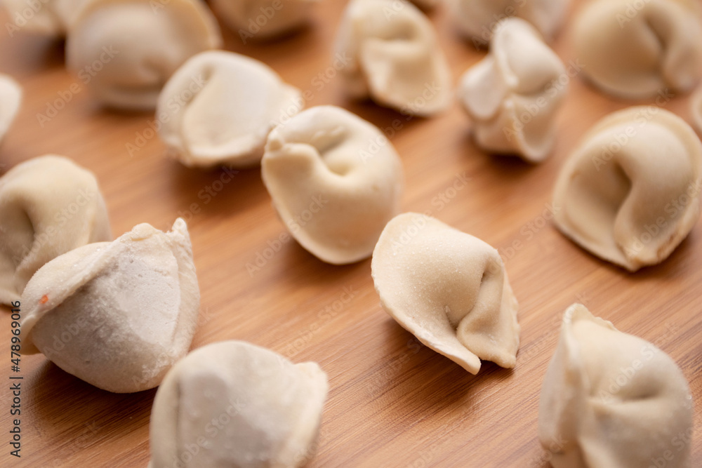 Frozen dumplings pelmeni on a wooden board Frozen dumplings pelmeni on a wooden board