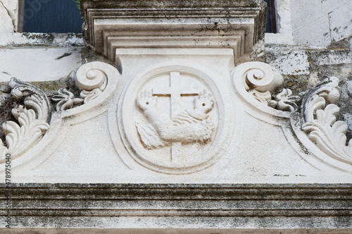Religious symbol, Franciscan coat of arms, cross with two arms with two arms crossing each other, carved in white stone, in Zadar, Croatia photo