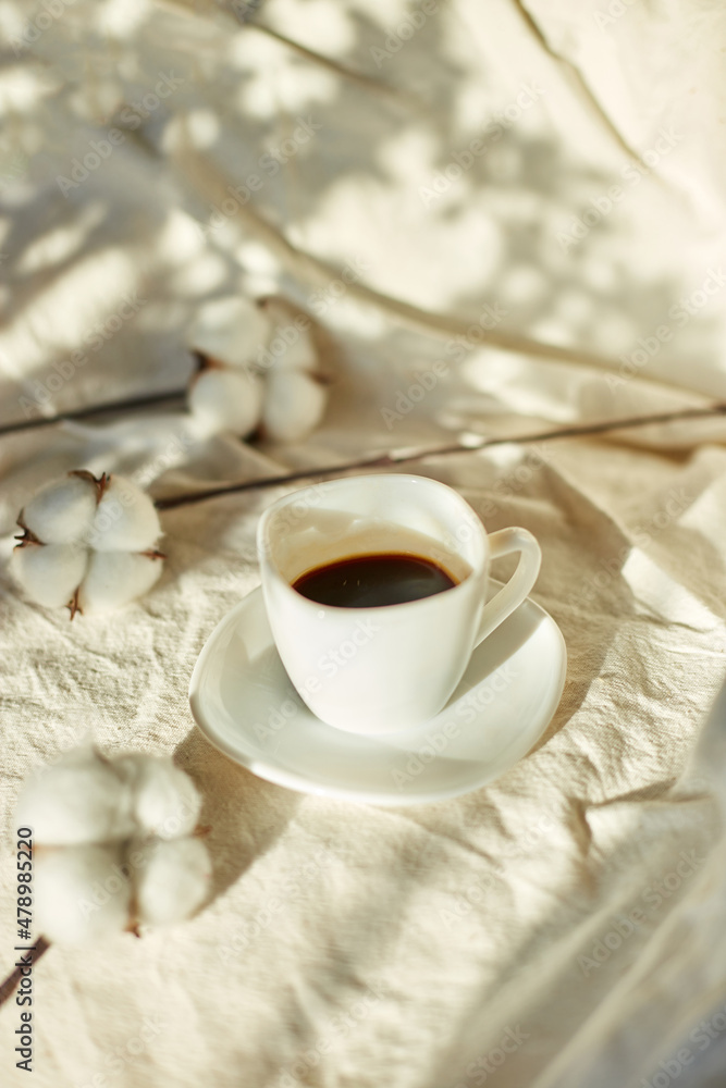Cup of coffee in bed with cotton flowers, morning mood, Organic and natural linen cotton textile bedclothes, copy space. Cup of coffee in bed with cotton flowers, morning mood, Organic and natural linen cotton textile bedclothes, copy space.