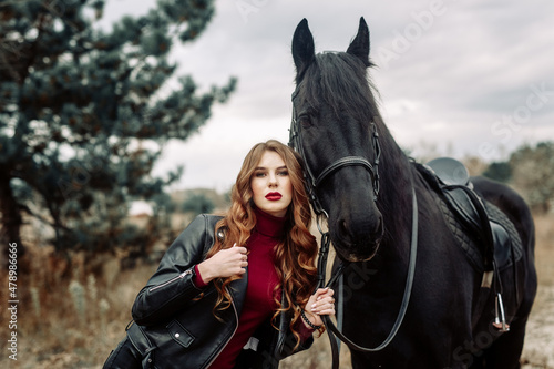 Beautiful young woman posing with a horse outdoors, close up