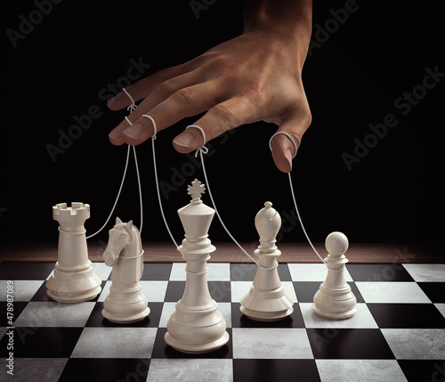 Fotografiet puppeteer hands controlling chess piece