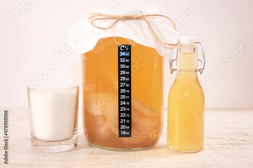 Homemade kombucha tea, glass Jar with SCOBY, sugar and a bottle of finished kombucha