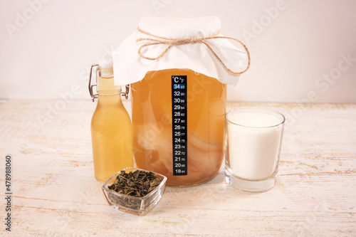 Homemade Fermented Raw Kombucha Tea in a glass jar, tea, sugar and a bottle 
