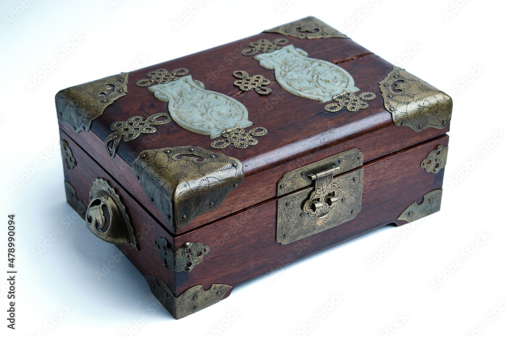 Old wooden box with patinated brass elements on a light background. Close-up. Selective focus Old wooden box with patinated brass elements on a light background. Close-up. Selective focus