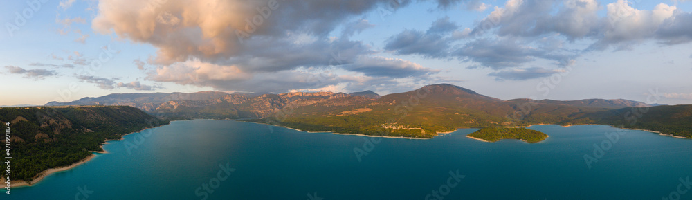 The panoramic view of Lac de Sainte-Croix in the middle of mountains and forests in Europe, France, Provence Alpes Cote dAzur, Var, in the summer on a sunny day.