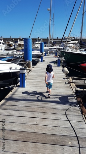 harbor with bridge boats and yachts boy walking on the brigde