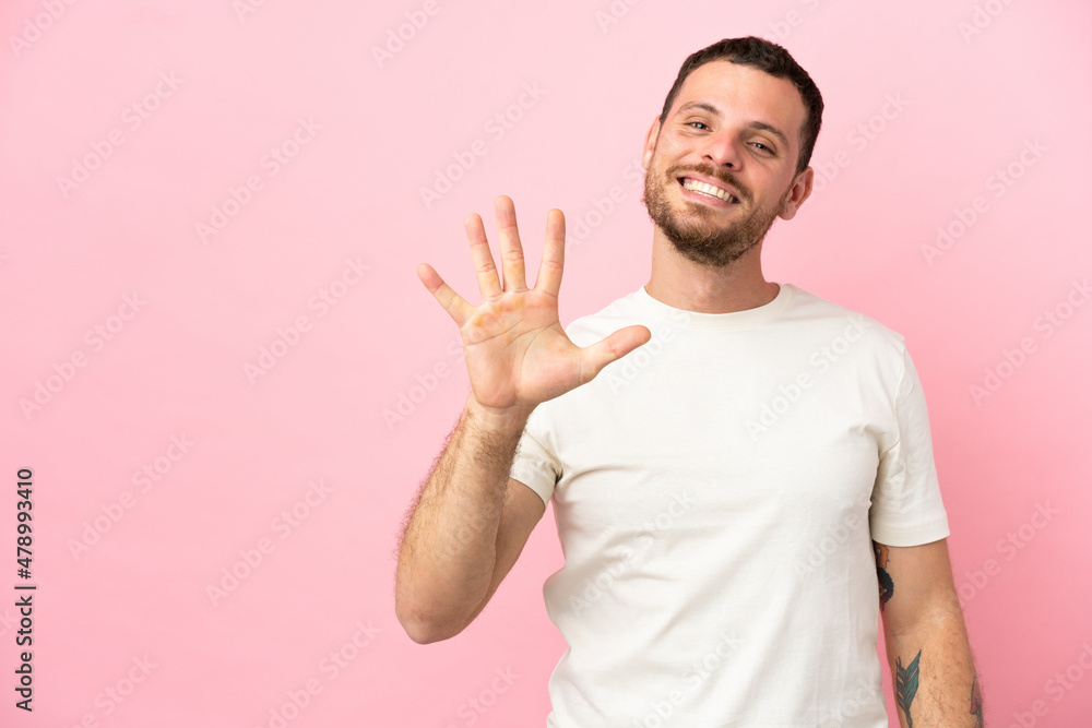 Young Brazilian man isolated on pink background counting five with fingers Young Brazilian man isolated on pink background counting five with fingers