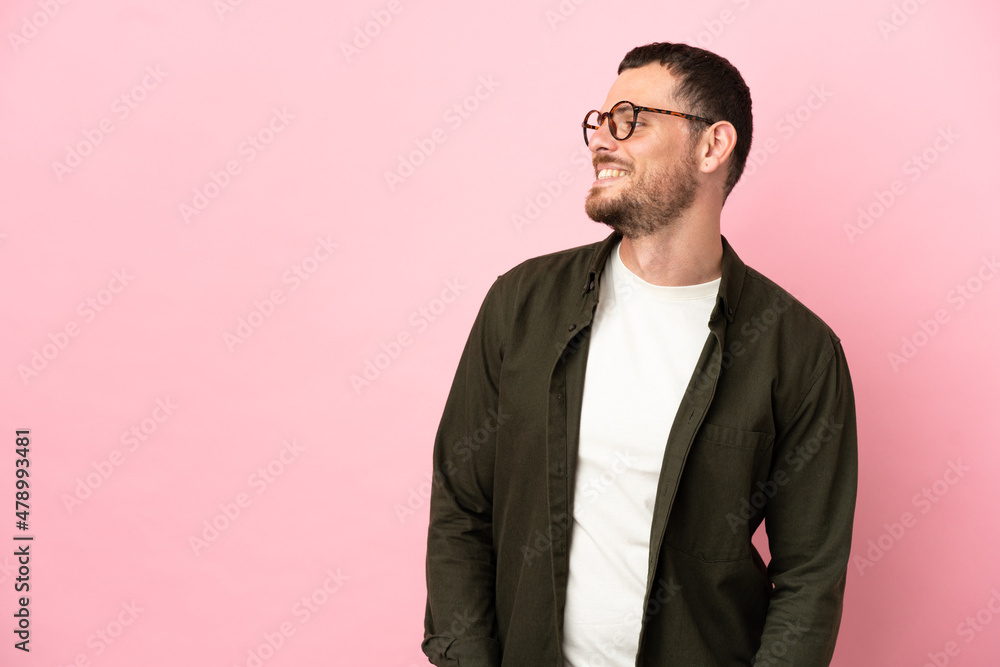Young Brazilian man isolated on pink background looking side Young Brazilian man isolated on pink background looking side