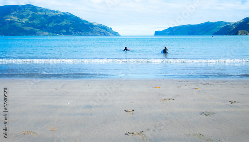 Two boys learning to surf on the New Zealand coast of the South Island in Wainui in the Summer. photo