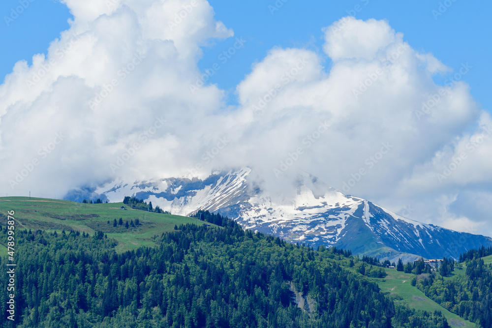 Mont Joly and Col de Voza in the clouds in the Mont Blanc Massif in Europe, France, the Alps, towards Chamonix, in summer, on a sunny day.