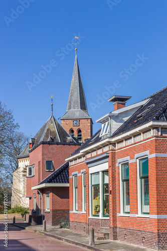 Street with houses and church tower in Warffum, Netherlands
