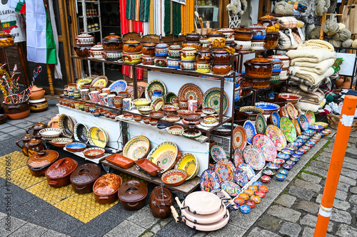 Pots, bowls, plates for sale on the street market. Colorful souvenirs on the stand.