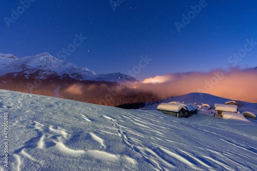 Mountain huts covered with snow under the starry winter sky, Andossi, Madesimo, Valchiavenna, Valtellina, Lombardy, Italy photo