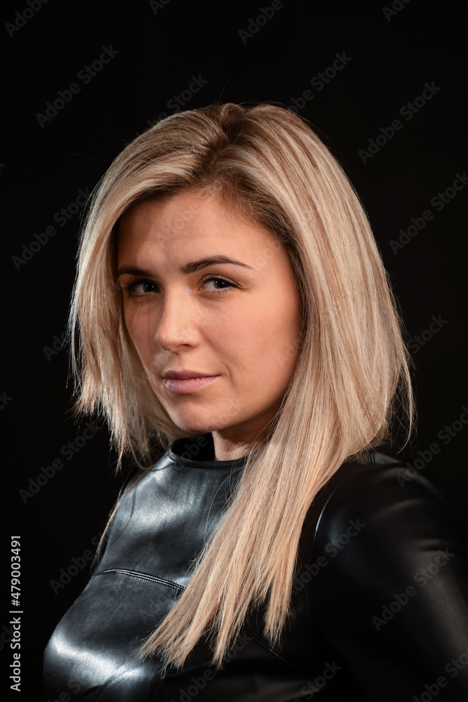 Young attractive girl of blonde model appearance with long hair on a dark background Young attractive girl of blonde model appearance with long hair on a dark background