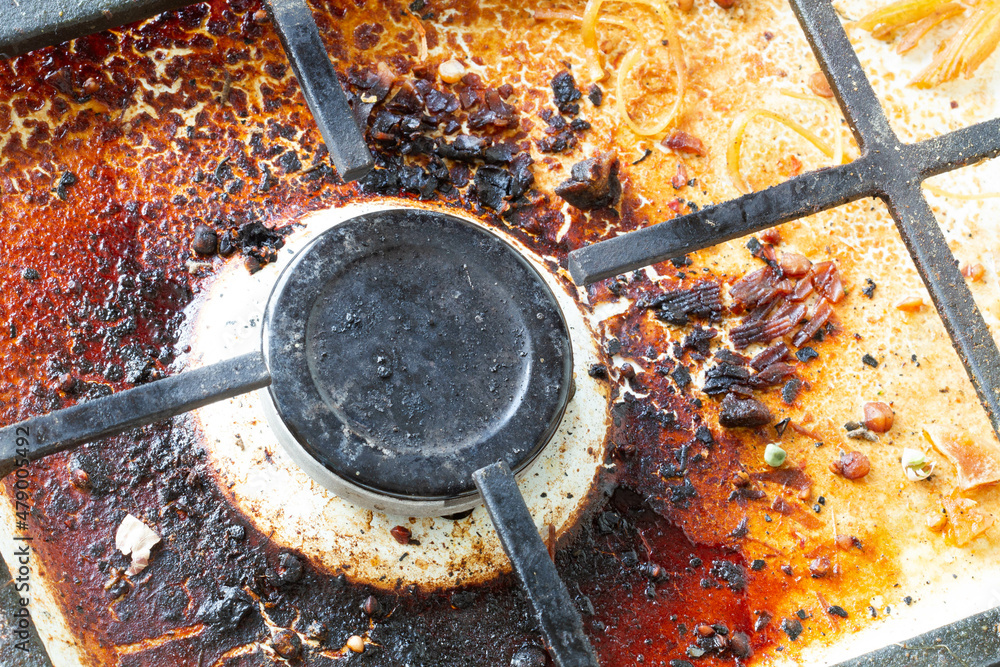 Dirty gas stove surface. Gas gas burner and cast iron grate of a gas