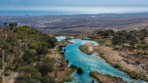 Aerial of a turquoise river in Wadi Darbat, Salalah