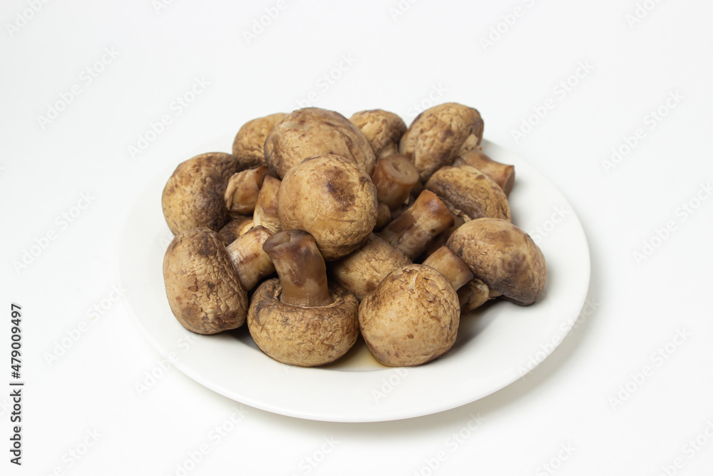 Boiled mushrooms on a white background. Boiled champignons on a white plate. Healthy diet Boiled mushrooms on a white background. Boiled champignons on a white plate. Healthy diet
