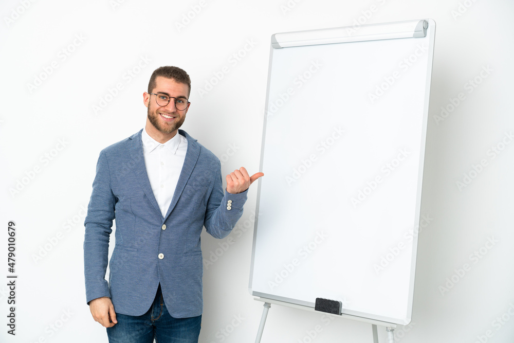 Young business woman giving a presentation on white board isolated on white background pointing to the side to present a product Young business woman giving a presentation on white board isolated on white background pointing to the side to present a product